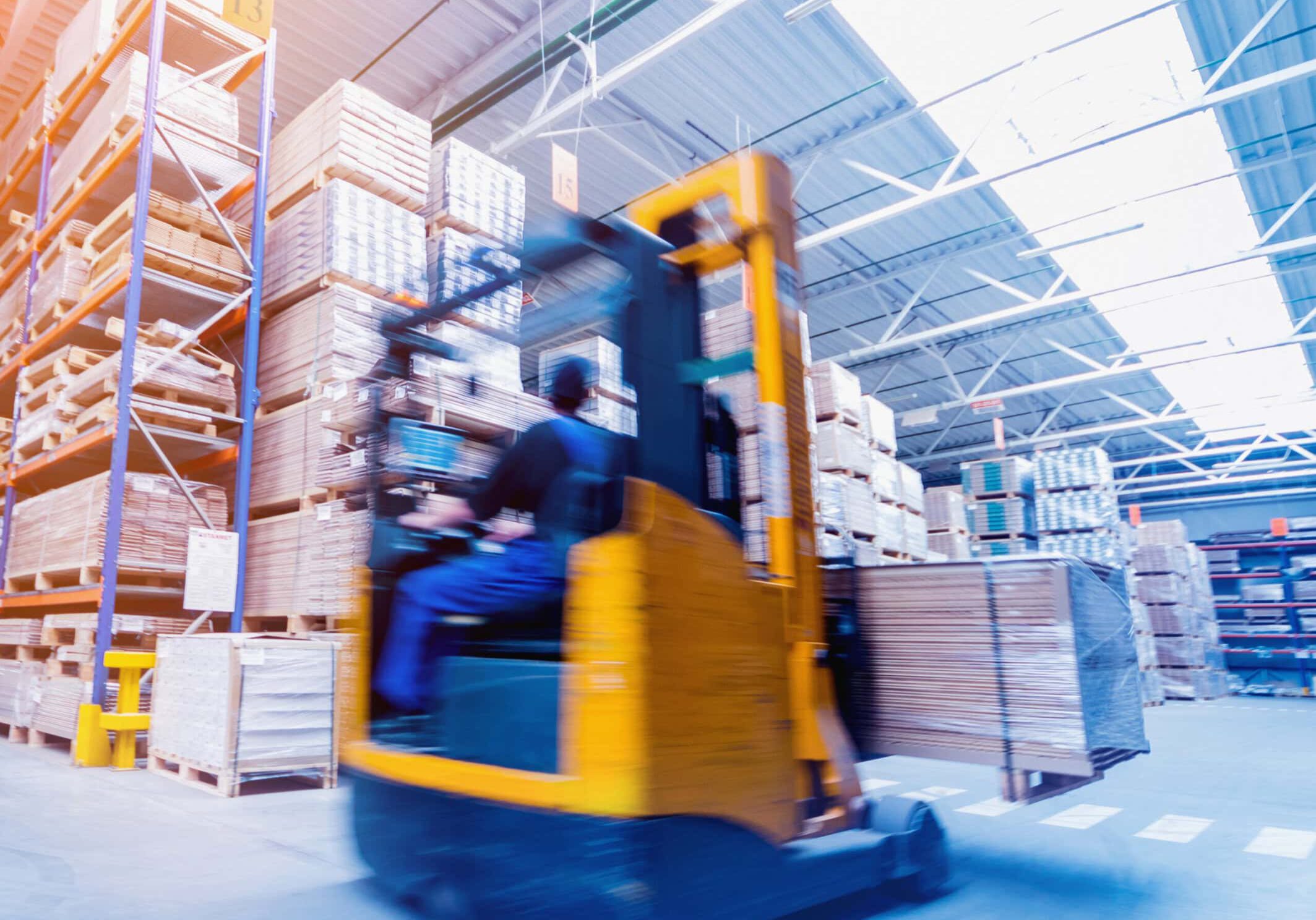 Warehouse forklift moving stacked pallets