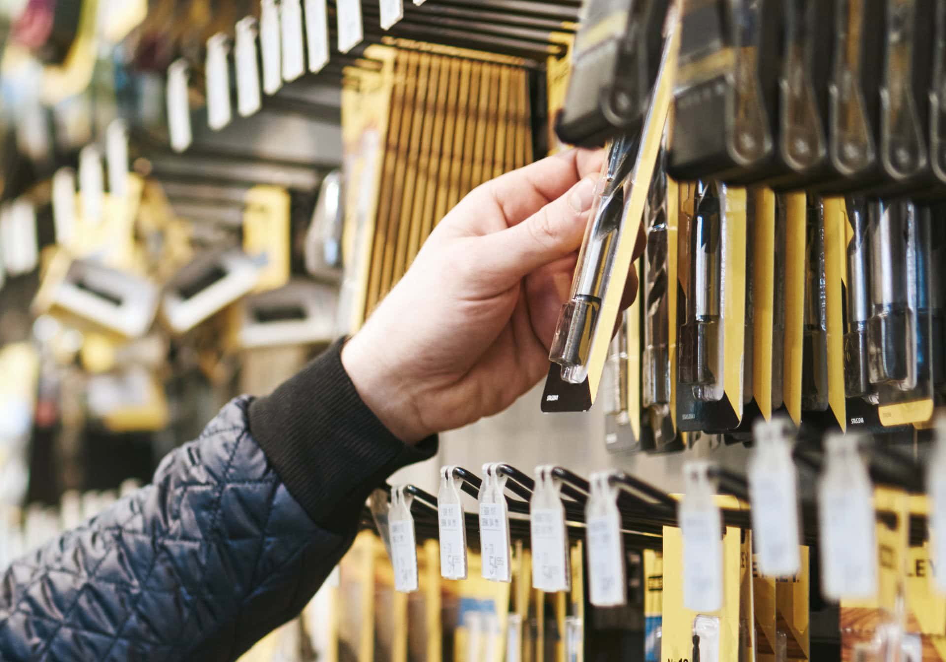 Person shopping for hardware tools in store.